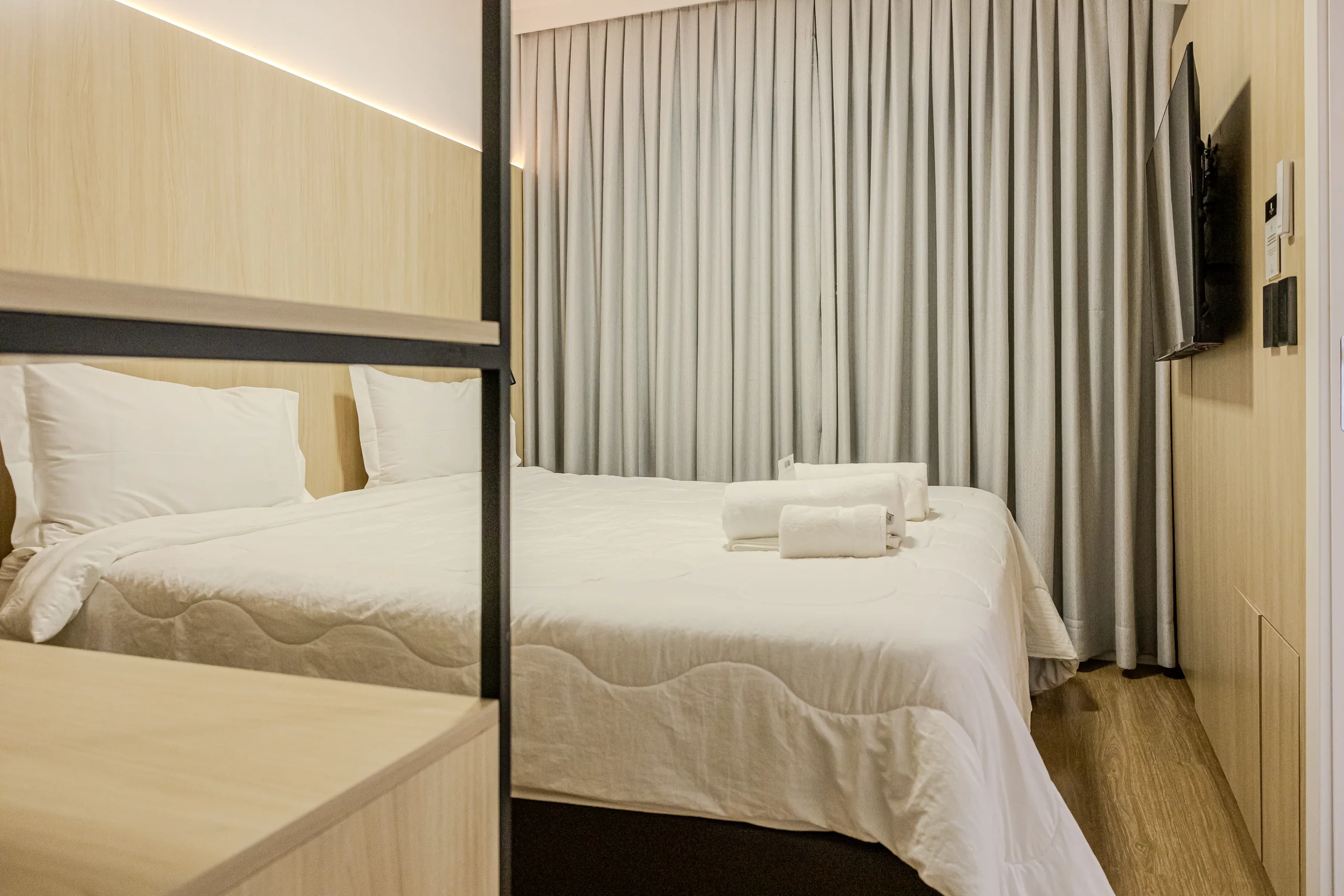 Quarto visto a partir da circulação, com cama e estante aberta.
