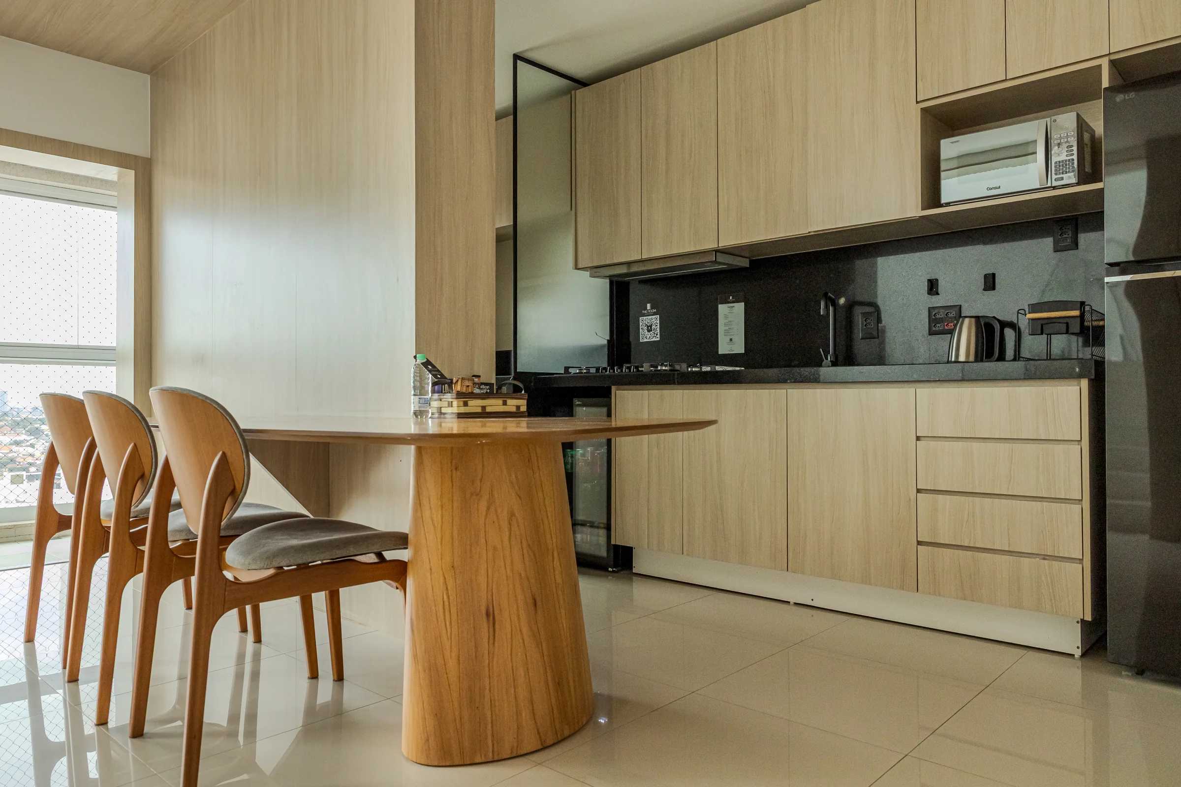 Cozinha completa com mesa de madeira e quatro cadeiras.